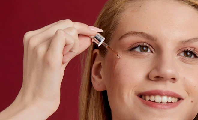 ARYA LAYA Seren und Fluids Frau trägt ein Serum mit einer Pipette auf die zarte Augenpartie auf